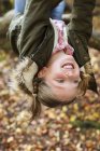 Girl hanging upside down on tree branch. — Stock Photo