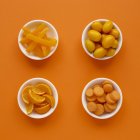 Fresh produce in dishes on orange background. — Stock Photo