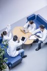 Team of doctors discussing work in hospital lobby. — Stock Photo