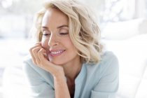 Mature woman smiling and looking away. — Stock Photo