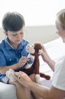 Boy playing with stethoscope and stuffed monkey. — Stock Photo