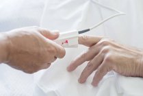 Nurse applying pulse oximeter on patient hand, close-up. — Stock Photo