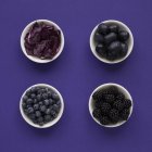 Lila Produkte in Gerichten auf violettem Hintergrund. — Stockfoto