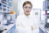 Female laboratory assistant standing with arms folded. — Stock Photo