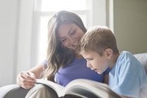 Mãe e filho lendo livro juntos . — Fotografia de Stock