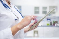 Обрезанный взгляд на женщину-врача с помощью цифрового планшета . — стоковое фото