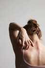 Woman scratching itchy back, rear view. — Stock Photo