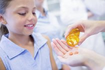 Doctor giving pills to young girl. — Stock Photo