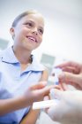 Doctor giving young girl finger prick test. — Stock Photo