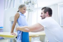 Médico preparando chica joven para rayos X en el hospital . - foto de stock