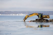 Bulldozer escavando rochas do mar . — Fotografia de Stock