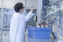 Chemist holding vial in pharmaceutical laboratory. — Stock Photo