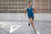 Мужчина в спортивной одежде бежит по дороге . — стоковое фото