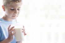 Мальчик-подросток пьет молочный коктейль с соломой — стоковое фото