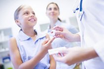 Doctor giving young girl finger prick test. — Stock Photo