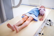Junges Mädchen mit Teddybär zur Röntgenuntersuchung. — Stockfoto