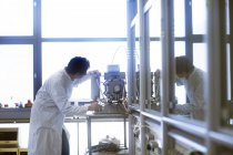 Un chimiste installe une pompe à vide dans un laboratoire pharmaceutique . — Photo de stock