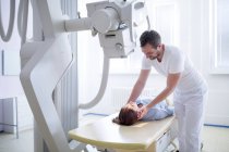 Medico regolazione del collo paziente femminile prima della radiografia . — Foto stock