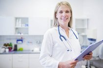 Female doctor standing with clipboard, portrait. — Stock Photo