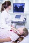 Sonographer performing ultrasound on girl neck. — Stock Photo