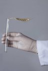 Hand in latex glove holding test tube with ear of wheat — Stock Photo