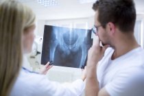 Doctors holding x-ray of male human pelvis. — Stock Photo