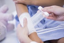 Enfermeira aplicando bandagem no braço da criança, close-up — Fotografia de Stock