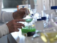 Scienziato che prepara liquido chimico in fiaschetta da laboratorio
. — Foto stock