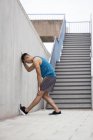 Молодой человек, протягивающий ногу к стене лестницы . — стоковое фото