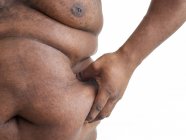 Hombre con sobrepeso pellizcando el cuerpo en la cintura, primer plano . - foto de stock