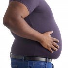Hombre con sobrepeso con la mano en el estómago, vista lateral . - foto de stock