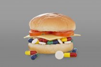 Píldoras antibióticas en hamburguesa, toma de estudio conceptual . - foto de stock