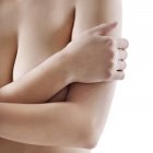 Woman covering breasts on white background. — Stock Photo