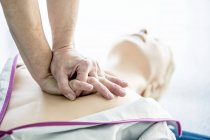 Doctor practicing chest compression on cardiopulmonary resuscitation training dummy. — Stock Photo