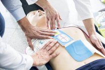Primeros auxilios practicando reanimación cardiopulmonar en maniquí de entrenamiento . - foto de stock