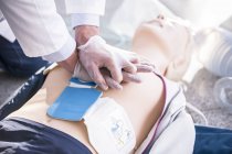 First-aider practicing cardiopulmonary resuscitation on training dummy. — Stock Photo