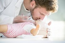 Чоловік лікар практикує серцево-легеневу реанімацію на тренувальній манері для немовлят . — стокове фото