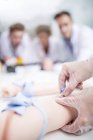 Étudiants en médecine pratiquant l'insertion de la ligne intraveineuse sur le mannequin de formation . — Photo de stock