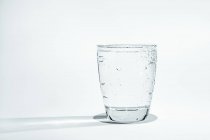 Склянка води з конденсатом на білому тлі . — стокове фото