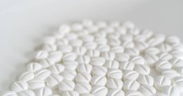 Weiße Pillen auf weißem Hintergrund, Nahaufnahme. — Stockfoto
