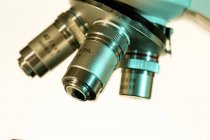 Primer plano de las lentes del microscopio de luz sobre fondo blanco . - foto de stock