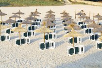 Лежаки и зонтики на песчаном пляже . — стоковое фото