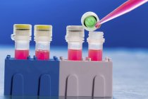 Close-up of pipette pipetting into test tubes in pathogenic laboratory. — Stock Photo