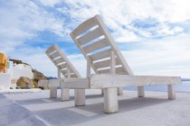 Liegestühle auf der terrasse oia, santorini, griechenland. — Stockfoto