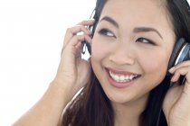 Porträt einer fröhlichen jungen Frau, die über Kopfhörer Musik hört. — Stockfoto