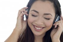 Porträt einer fröhlichen jungen Frau, die über Kopfhörer Musik hört. — Stockfoto