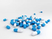 Ilustração digital de cápsulas de drogas azuis e brancas no fundo branco . — Fotografia de Stock