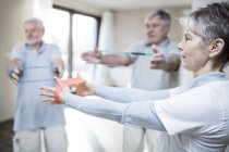 Senior adults using resistance bands in exercise class. — Stock Photo