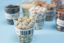 Grains and pulses in plastic cups for agriculture research, conceptual image. — Stock Photo