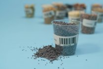 Semillas de amapola en taza de plástico para la investigación agrícola, imagen conceptual . - foto de stock